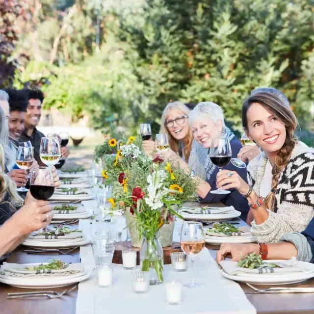 Amigos em uma mesa compartilhando uma degustação de vinhos ao ar livre